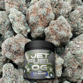 Jar labeled 'JET FUEL OG' surrounded by flower