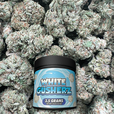 Jar of 'White Gushers' candy surrounded by green buds